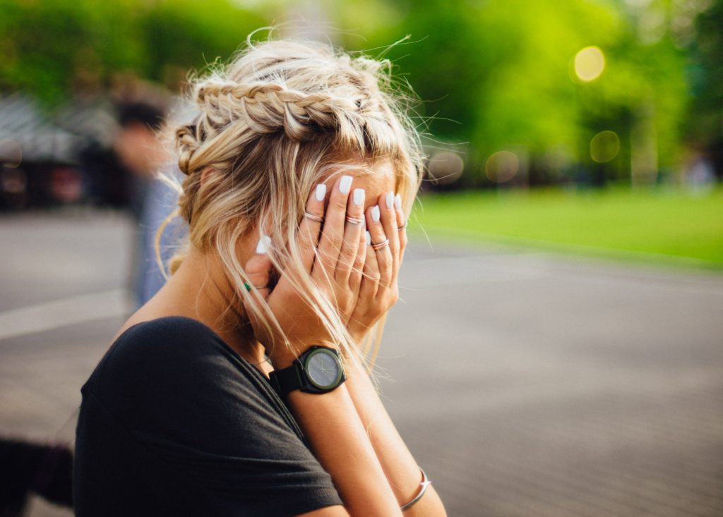 Woman holding her face in her hands