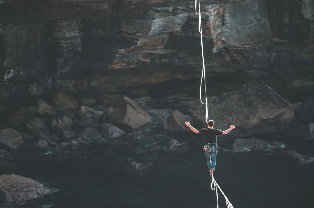 man walking on a wire over a cavern