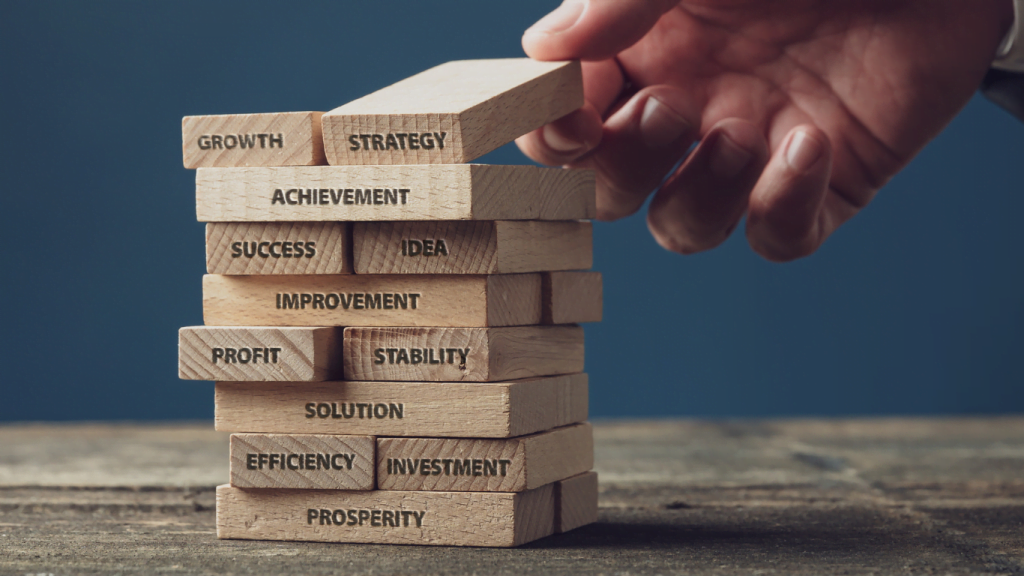 hand stacking blocks with words relating to small business development