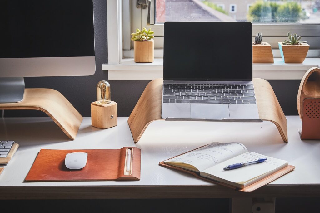 black and silver laptop on brown stand