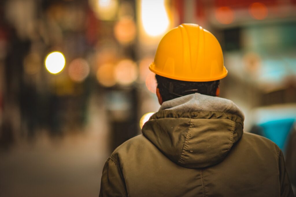 person in yellow hard hat facing away from the camera