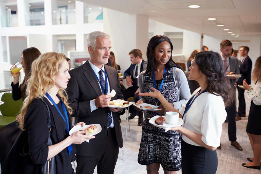 people standing with appetizers chatting